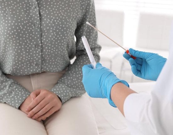 how to detect and treat STDs Doctor taking sample for STD testing from woman in clinic, closeup